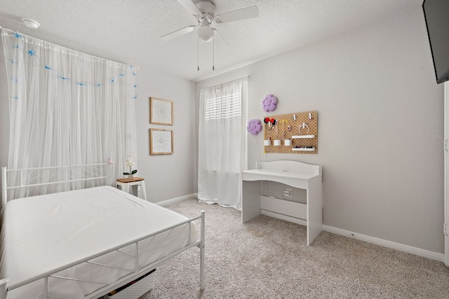 carpeted bedroom with a textured ceiling and ceiling fan