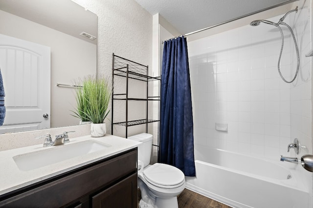 full bathroom featuring hardwood / wood-style floors, shower / tub combo, vanity, toilet, and a textured ceiling