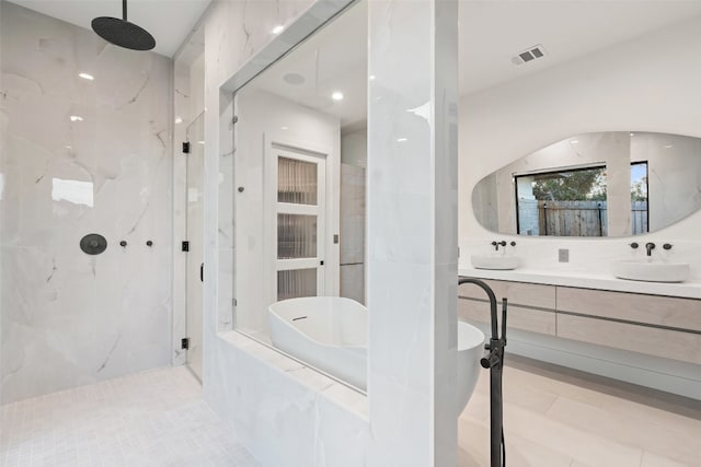 bathroom featuring plus walk in shower, tile patterned flooring, and vanity