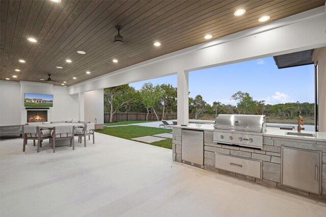 1007 County Road 290, Leander, TX 78641 - view of patio / terrace with a warm lit fireplace, fence, a sink, and area for grilling