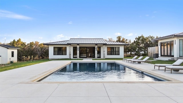 1007 County Road 290, Leander, TX 78641 - rear view of property featuring a standing seam roof, metal roof, an outbuilding, an outdoor pool, and a patio area