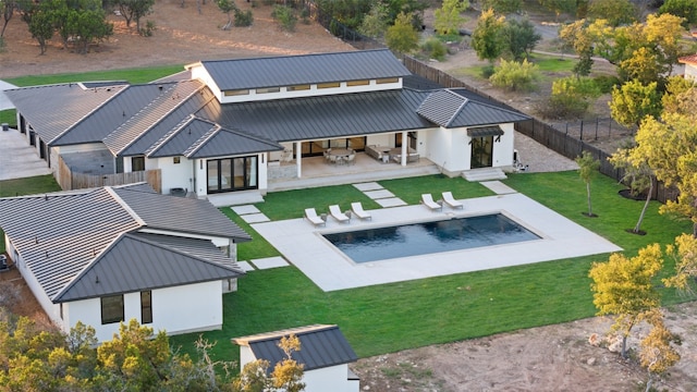 rear view of property with a patio, a fenced in pool, and a yard