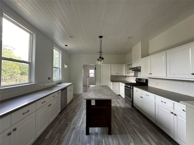 kitchen with sink, white cabinets, stainless steel appliances, decorative light fixtures, and dark hardwood / wood-style flooring