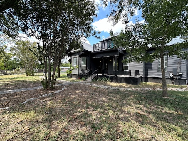 exterior space featuring a balcony and a yard