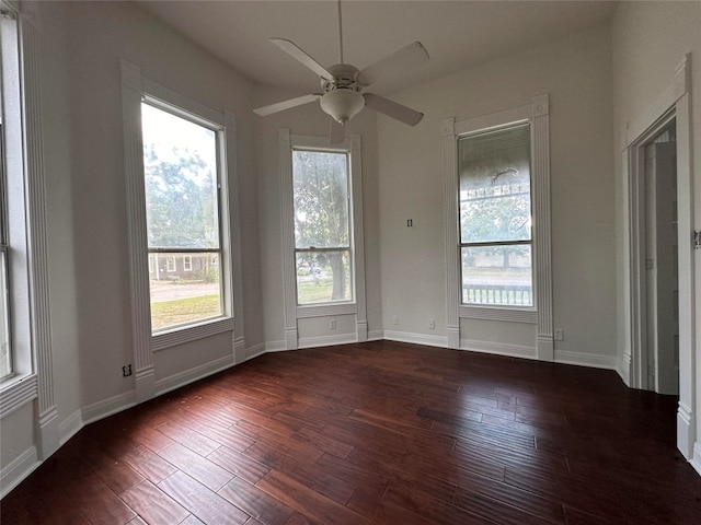 unfurnished room featuring ceiling fan, dark hardwood / wood-style floors, and a wealth of natural light