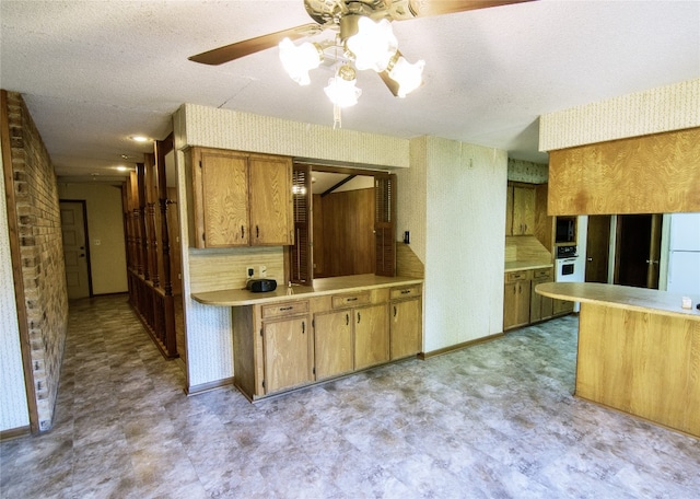 kitchen featuring a textured ceiling, decorative backsplash, white oven, and ceiling fan