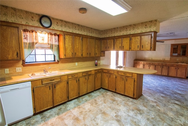 kitchen with dishwasher, sink, kitchen peninsula, and a textured ceiling