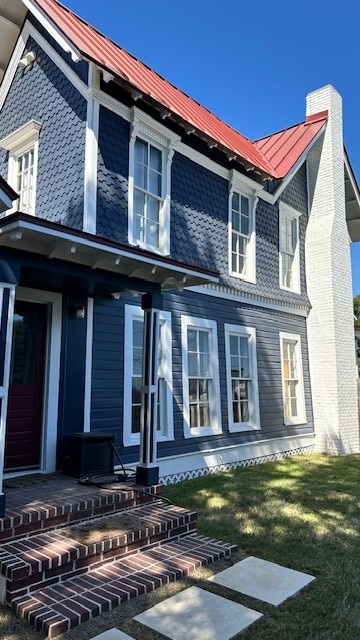 rear view of property featuring a lawn