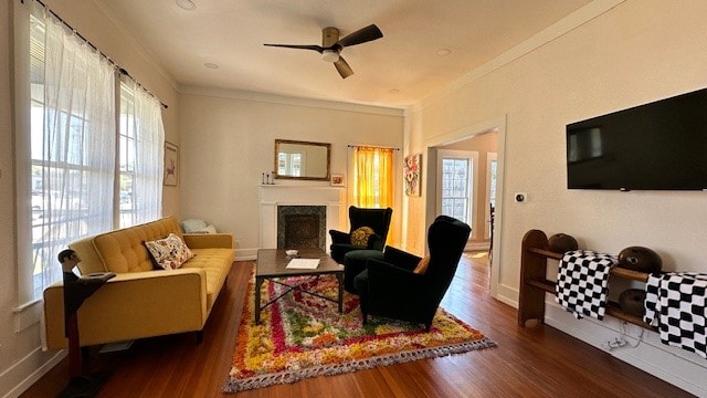 living room featuring crown molding, ceiling fan, and dark wood-type flooring