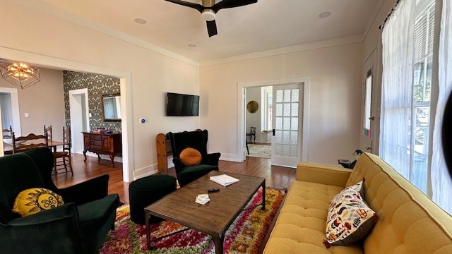 living room featuring hardwood / wood-style floors, ceiling fan, and crown molding