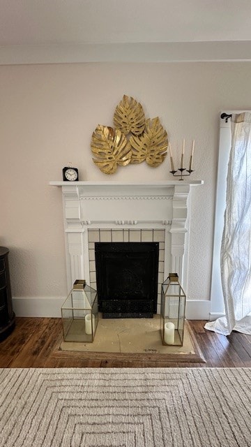 room details featuring wood-type flooring and a tile fireplace