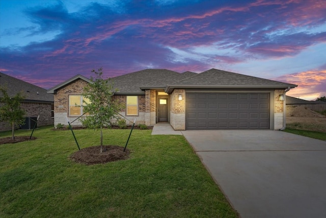 view of front of property with a lawn, a garage, and central AC unit