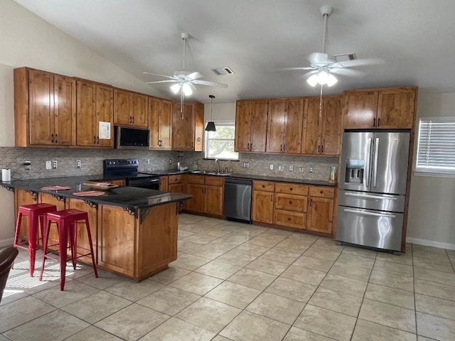 kitchen featuring ceiling fan, sink, kitchen peninsula, backsplash, and stainless steel appliances