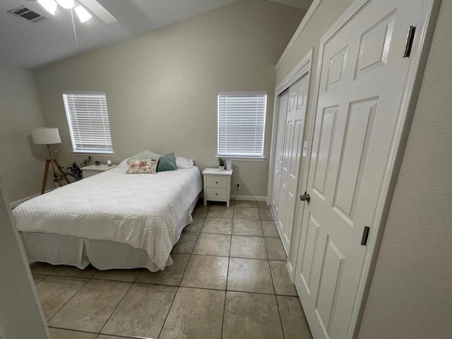 bedroom featuring ceiling fan, light tile patterned floors, and vaulted ceiling