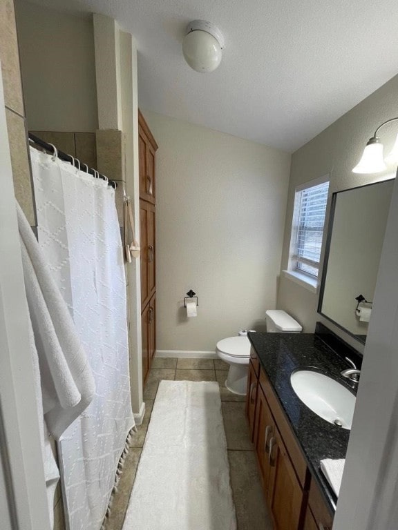 bathroom with vanity, tile patterned flooring, toilet, and a textured ceiling