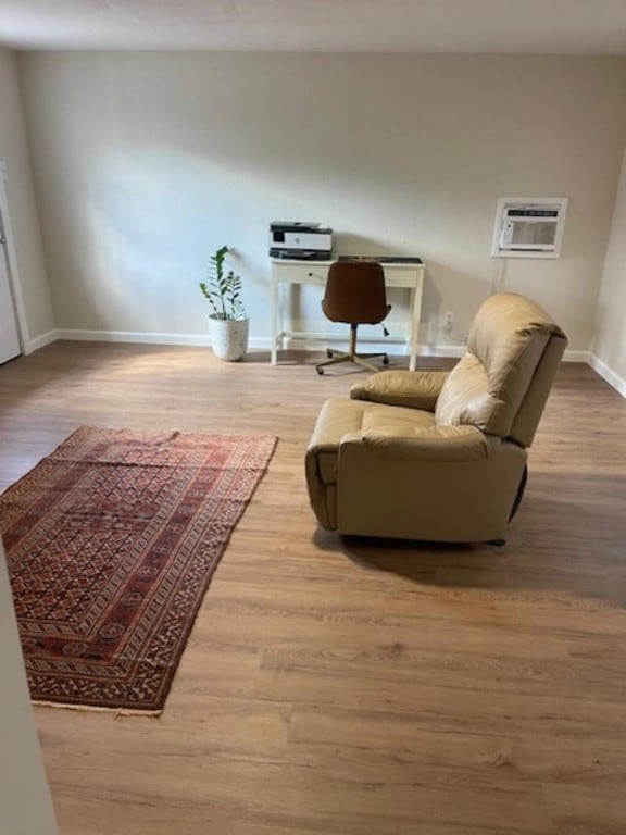 living room featuring hardwood / wood-style flooring and a wall mounted air conditioner