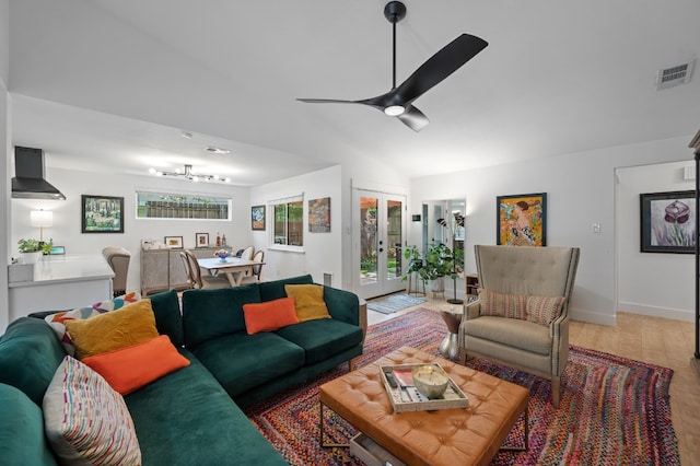 living area with ceiling fan, lofted ceiling, light wood-style flooring, visible vents, and french doors