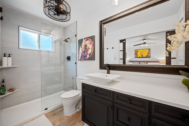 bathroom with vanity, walk in shower, toilet, ceiling fan, and hardwood / wood-style floors