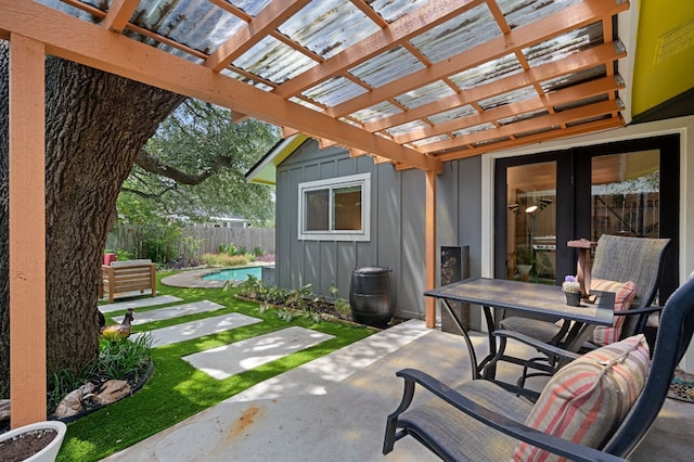 view of patio / terrace with a fenced in pool, fence, a pergola, and outdoor dining space