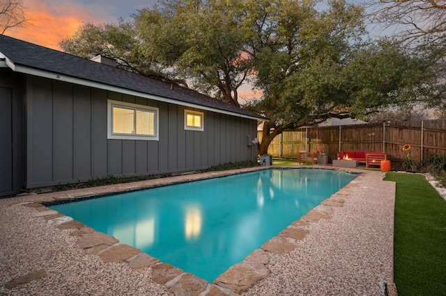 pool at dusk featuring a fenced in pool, fence, and an outdoor living space