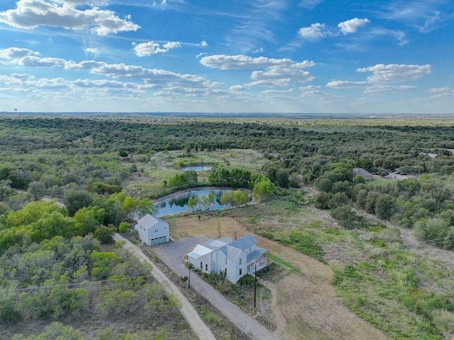 birds eye view of property with a water view and a wooded view