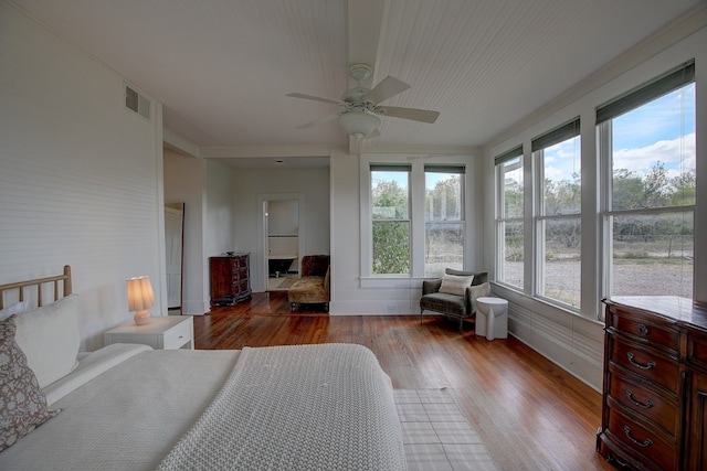 bedroom featuring ceiling fan, light hardwood / wood-style floors, and multiple windows