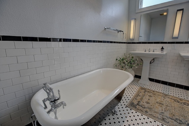 bathroom featuring tile walls, tile patterned floors, and a washtub