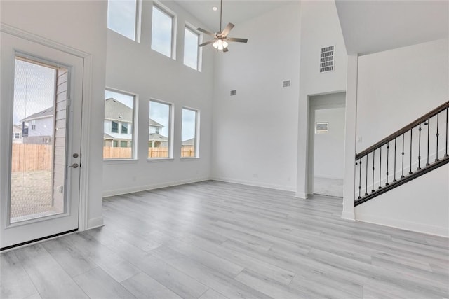 unfurnished living room featuring ceiling fan, light wood-style flooring, visible vents, and baseboards