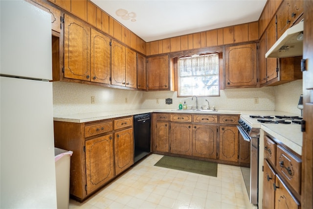 kitchen featuring dishwasher, white refrigerator, sink, stainless steel stove, and backsplash