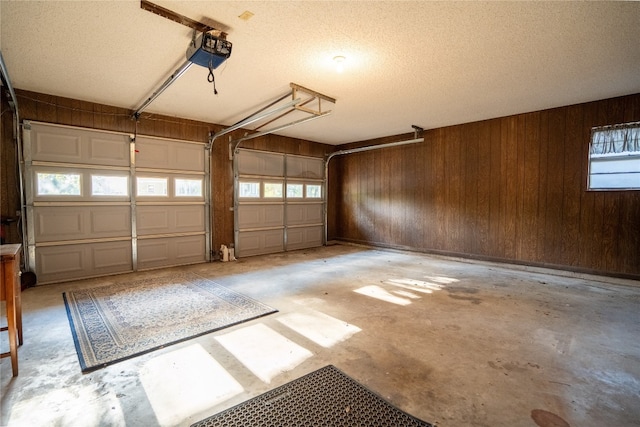 garage with a garage door opener and wood walls