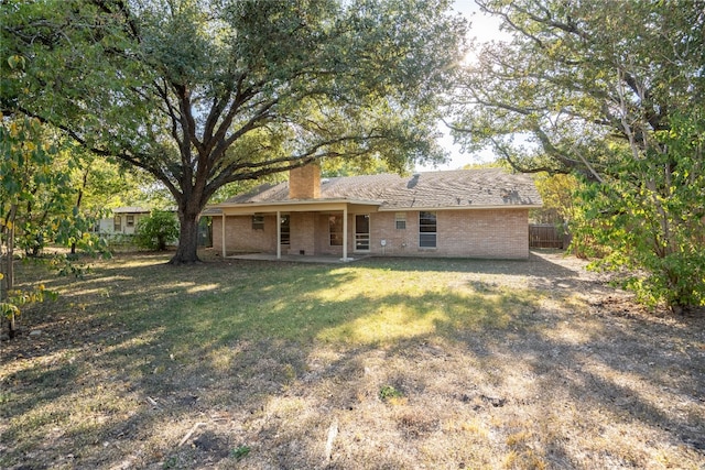 rear view of property featuring a lawn