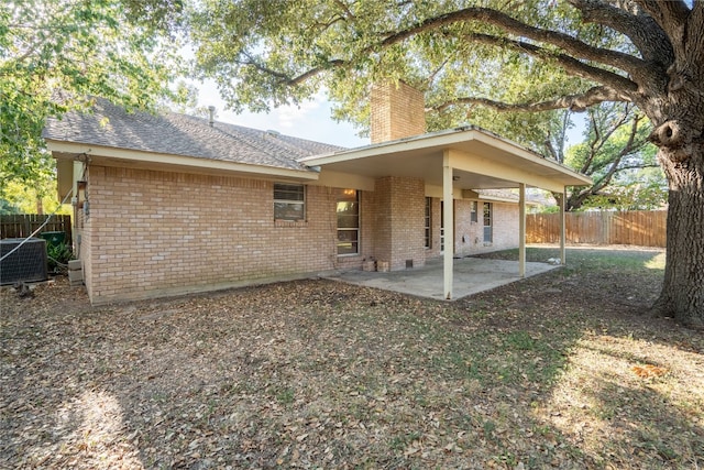 back of house with central AC unit and a patio