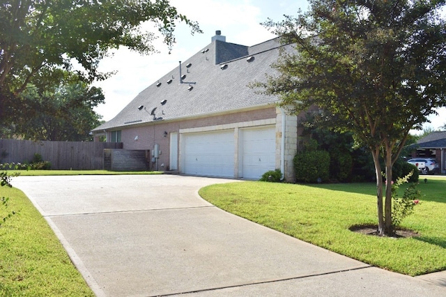 view of side of property with a lawn and a garage