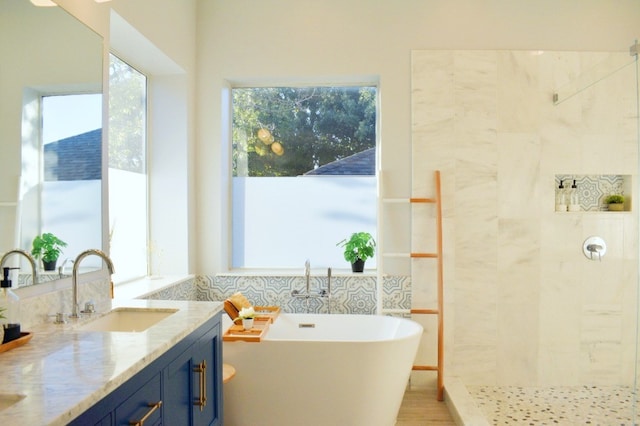 bathroom featuring shower with separate bathtub and vanity