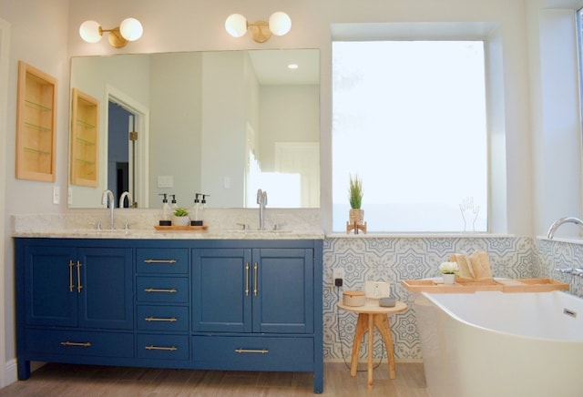 bathroom with a bathing tub, vanity, and wood-type flooring