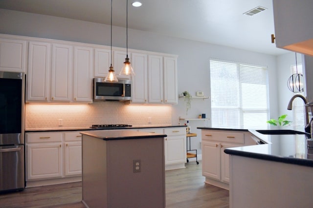 kitchen featuring white cabinetry, sink, light hardwood / wood-style floors, and appliances with stainless steel finishes