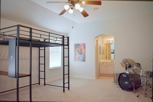 unfurnished bedroom with ceiling fan, lofted ceiling, light carpet, and ensuite bath