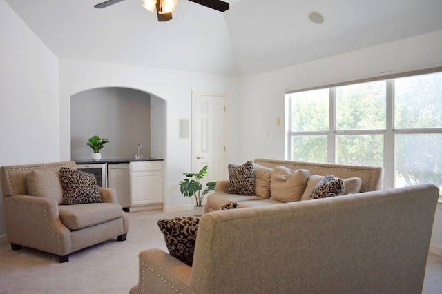 living room featuring lofted ceiling, sink, wine cooler, ceiling fan, and light colored carpet