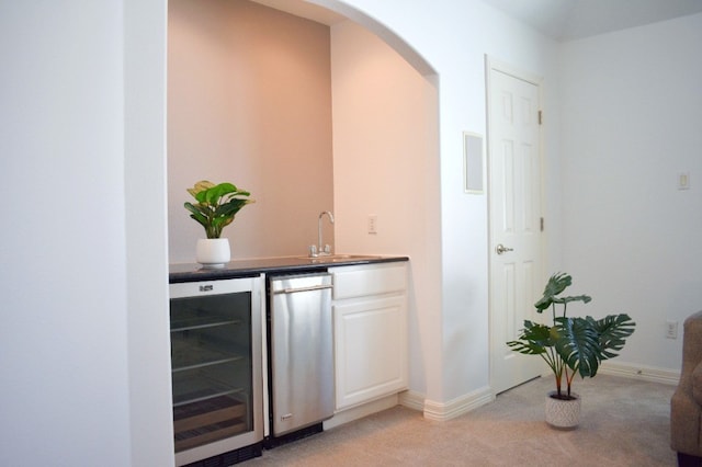 bar with light colored carpet, wine cooler, and sink