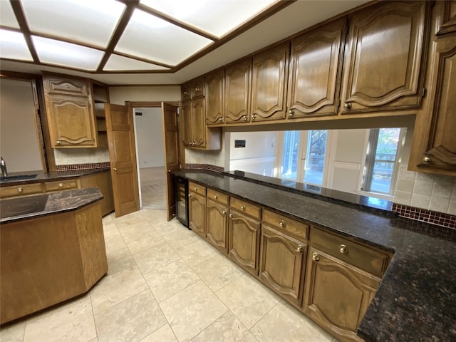 kitchen featuring dark stone counters, sink, and decorative backsplash