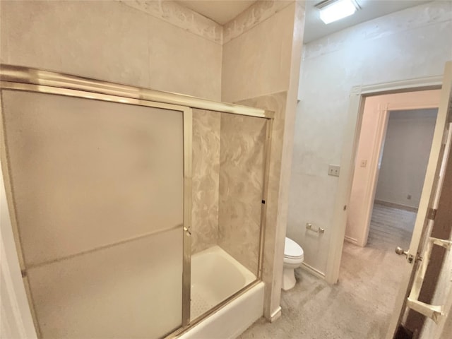 bathroom with toilet and combined bath / shower with glass door