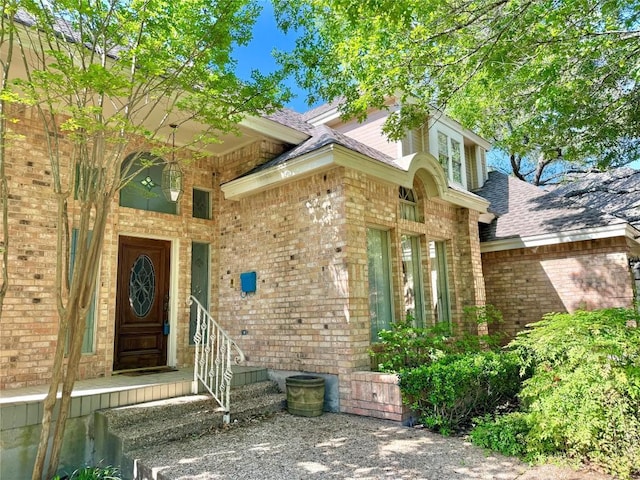 7011 Quill Leaf Cv, Austin, TX 78750 - view of exterior entry featuring a shingled roof and brick siding