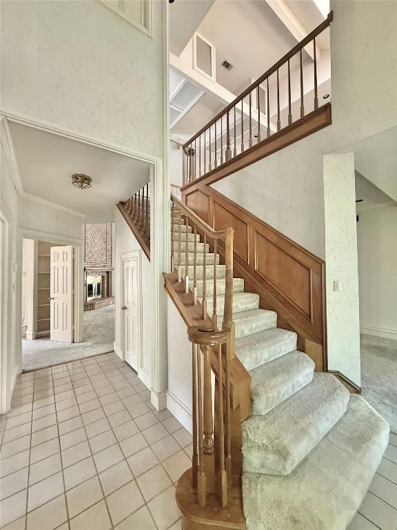 7011 Quill Leaf Cv, Austin, TX 78750 - stairs with a towering ceiling, tile patterned flooring, and ornamental molding
