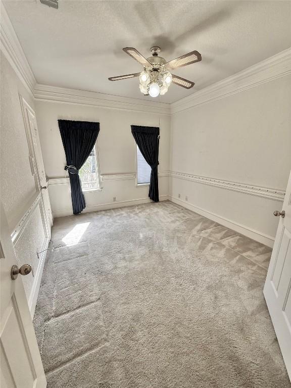 7011 Quill Leaf Cv, Austin, TX 78750 - empty room with light colored carpet, ceiling fan, crown molding, and a textured ceiling