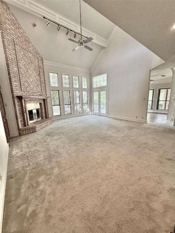7011 Quill Leaf Cv, Austin, TX 78750 - unfurnished living room featuring high vaulted ceiling, a ceiling fan, carpet floors, and healthy amount of natural light