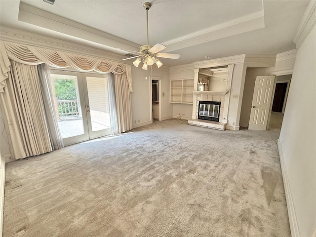 7011 Quill Leaf Cv, Austin, TX 78750 - unfurnished living room featuring carpet floors, french doors, a fireplace, a tray ceiling, and crown molding