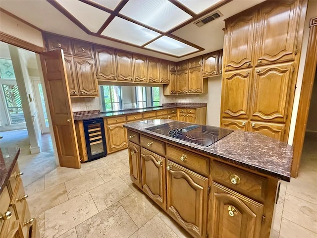 7011 Quill Leaf Cv, Austin, TX 78750 - kitchen with wine cooler, black electric stovetop, brown cabinetry, backsplash, and dark stone counters