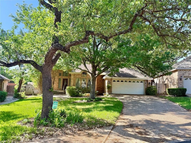 7011 Quill Leaf Cv, Austin, TX 78750 - view of property hidden behind natural elements with driveway, an attached garage, and brick siding