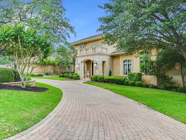 mediterranean / spanish-style home featuring a balcony and a front yard