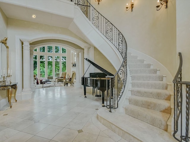 tiled foyer entrance with french doors, decorative columns, and a high ceiling